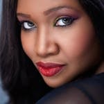 Stunning close-up portrait of a woman with vibrant makeup and confident expression.